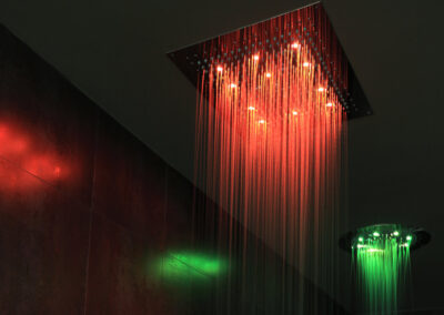 Red and green LED lit ceiling showers with water coming out